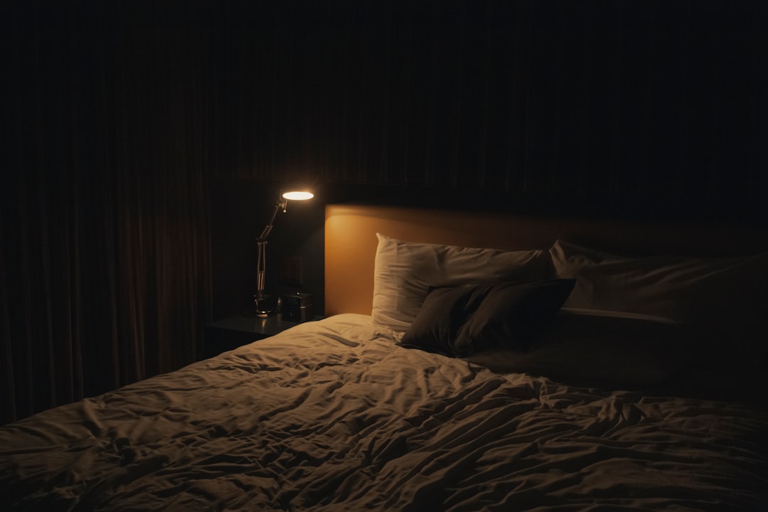 Cool, dim bedroom with breathable bedding set for comfortable sleep